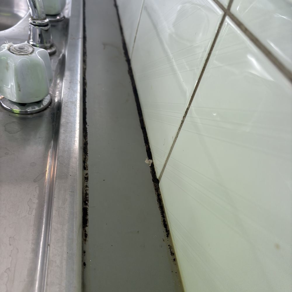 Perished sealant along a sink and splashback joint, found during a pre-purchase inspection in Braybrook
